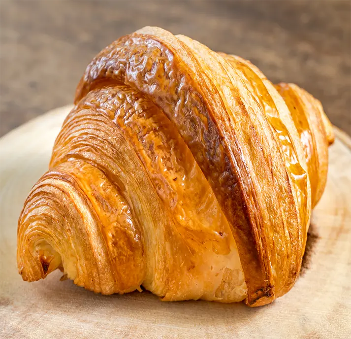 Delicious buttery layered croissant with flaky, crispy layers and a golden brown exterior.